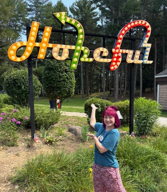 Dr Broadley outside pointing at a Hopefule sign.