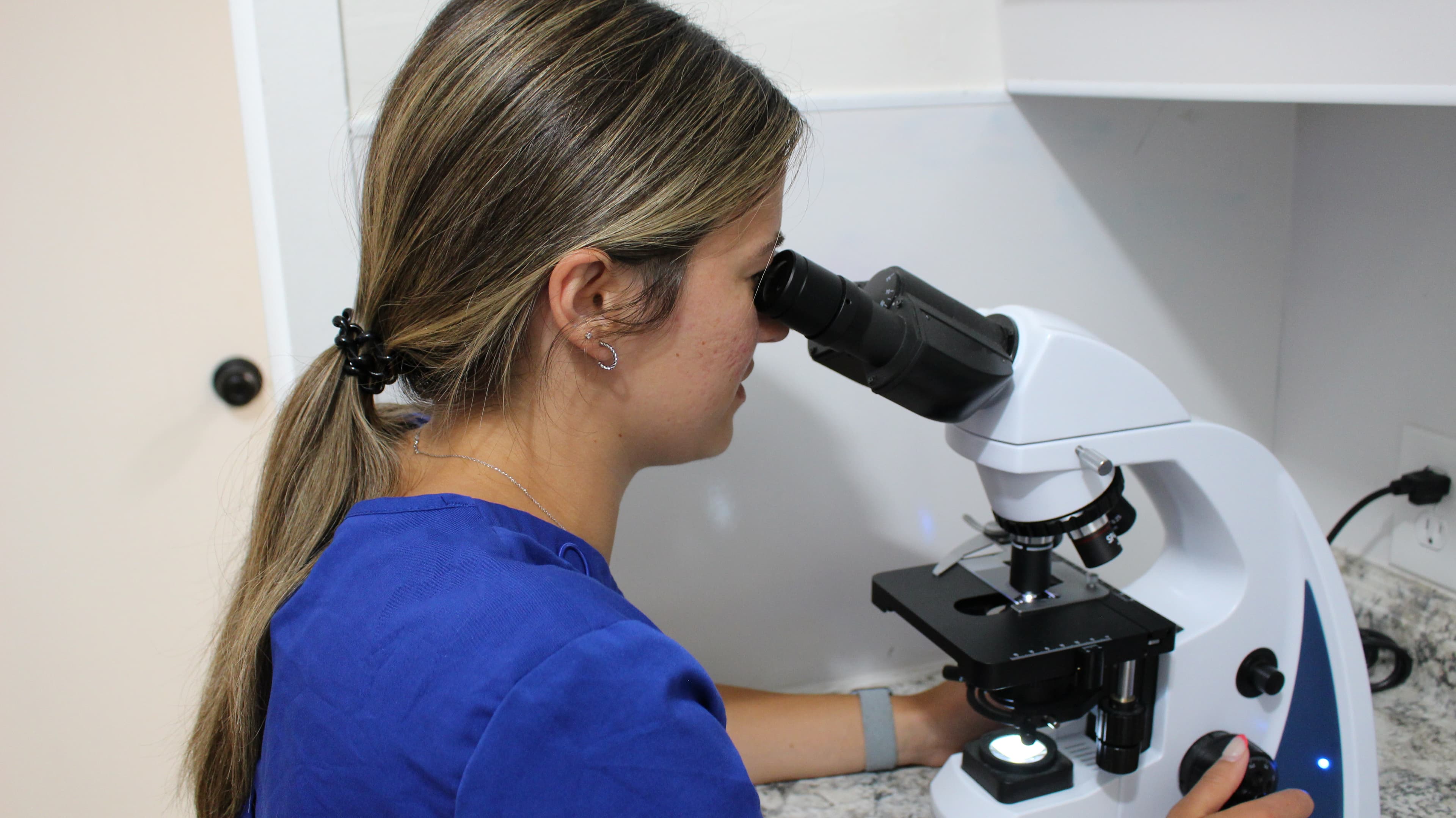 Ava looking through microscope