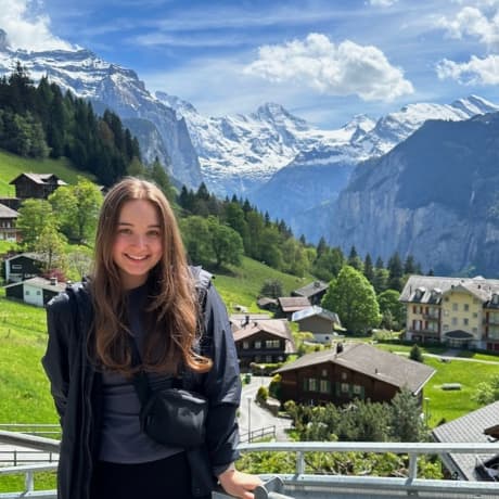 Erin, Practice Manager, smiling outdoors in front of a mountain valley.