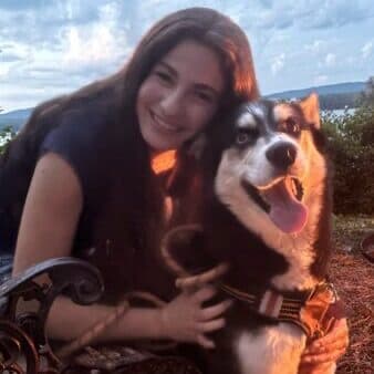 Teresa, Veterinary Assistant, outdoors at sunset with her husky Blaze.